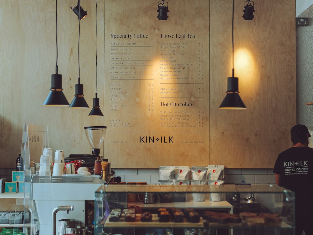 The counter at Kettle & Grain, lit by low pendant lamps, with stools along a timber bar